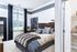 Contemporary bedroom with plush bedding, elegant decor, and ample natural light through large windows, perfect for comfort and style.
