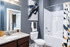 Elegant bathroom with sleek dark walls, modern granite countertop, and stylish abstract artwork.