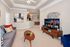 Elegant living room with modern decor featuring a comfortable gray sofa, decorative pillows, stylish wooden coffee table, large flat-screen TV, and an inviting open-concept dining area.