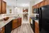 Modern kitchen with granite countertops, wooden cabinetry, and a cozy dining area with elegant lighting.