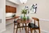 Elegant dining area with a chic wooden table, stylish chairs, and modern art accents, perfect for intimate gatherings.