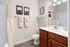 Elegant bathroom featuring sleek white countertops, rich wooden cabinetry, and modern decor with ambient lighting.