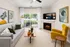 Bright and chic living room with a cozy fireplace, modern artwork, and comfortable seating, featuring a large window view and natural light.