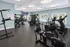 Modern fitness center with state-of-the-art exercise equipment and large windows providing natural light and a pool view.