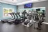 Modern fitness center featuring state-of-the-art treadmills, elliptical machines, and exercise bikes with bright natural lighting.