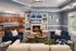 Inviting living room with cozy fireplace, stylish furniture arrangement, and an elegant open kitchen in the background.