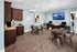 Modern communal space with stylish wooden cabinetry, marble countertop, and workstations, perfect for productivity and relaxation.