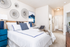 Modern and inviting bedroom with chic decor, featuring plush bedding, artistic wall accents, and a cozy ambiance.