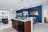 Modern apartment interior featuring an elegant kitchen with granite countertops, an open-concept living room, and stylish blue accent walls.