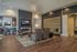 Chic living room with modern fireplace, elegant seating, and open kitchen, featuring stylish pendant lighting and cozy ambiance.