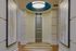 Elegant apartment hallway featuring contemporary artwork, modern lighting, and polished wood flooring.