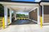 Bright and spacious covered carport with modern design and lush greenery, perfect for convenient and stylish outdoor parking.