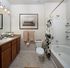 Modern bathroom featuring elegant cabinetry, chic tile flooring, and stylish shower curtain, offering a serene and sophisticated retreat.