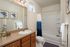 Elegantly designed bathroom featuring modern fixtures, chic lighting, and tasteful decor. Includes a sleek vanity, pristine bathtub, and stylish shower curtain accentuating a fresh and inviting ambiance.