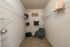 Spacious walk-in closet with elegant shelving, comfortable seating, and ample storage space.