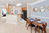 Charming apartment interior featuring a modern dining area with sleek wooden furniture, open kitchen with stylish accents, and cozy carpeted living spaces.