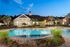 Luxurious apartment complex with a sparkling swimming pool and elegant clubhouse surrounded by lush greenery, perfect for relaxation and leisure.