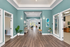 Welcoming lobby interior with elegant wood flooring, rich teal walls, and modern decor, highlighting spacious design and natural light.