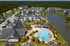 Beautiful apartment complex aerial view featuring elegant buildings, a large pool, and scenic pond surrounded by lush greenery.
