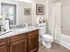 Modern bathroom featuring elegant granite countertop, stylish wooden vanity, and sophisticated decor.
