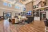 Elegant modern living room with high ceilings, large windows, stylish decor, and a cozy fireplace with built-in shelving.