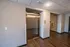 Modern apartment building hallway with sleek stainless-steel elevator, warm wood flooring, and ambient lighting.