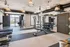 Modern fitness center with sleek equipment, ample natural light, and stylish lighting fixtures.