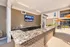 Chic outdoor kitchen area featuring elegant granite countertops and vibrant orange umbrellas, perfect for entertaining in style.