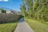 Inviting scenic path alongside a charming stone wall and lush green trees, perfect for outdoor strolls.