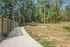 Charming woodland path with a wooden bridge, perfect for tranquil strolls and nature appreciation.