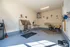 Bright and spacious pet grooming room featuring a modern wash station, stylish seating area, and charming pet-themed decor.