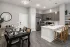 Spacious kitchen and dining area with gray cabinetry, island seating, and wood-look flooring at Abberly Royal Creek in Raleigh, NC.