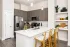 Open-concept kitchen with a large island, pendant lighting, and bar stools at Abberly Royal Creek in Raleigh, NC.