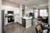 Modern apartment kitchen with island seating and stainless steel appliances at Abberly Royal Creek in Raleigh, NC.