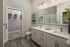 Primary bathroom with double-sink vanity and walk-in closet access at Abberly Royal Creek in Raleigh, NC.