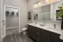 Bathroom with double vanity, glass-enclosed shower, and bedroom access at Abberly Royal Creek in Raleigh, NC.