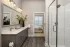 Bathroom with double-sink vanity, walk-in shower, and walk-in closet at Abberly Royal Creek in Raleigh, NC.