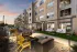 Outdoor community patio with seating, grilling area, and pool views at Abberly Royal Creek in Raleigh, NC.