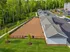 Scenic view of modern row house complex with landscaped green lawns and adjacent wooded area, ideal for serene suburban living.