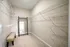 Spacious walk-in closet featuring ample shelving, a large mirror, and a stylish bench, perfect for organized and chic living.