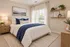 Elegant bedroom with cozy bedding, natural light, and stylish decor featuring plants and minimalist shelves.