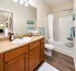 Elegant bathroom with warm wood cabinetry, modern fixtures, and a pristine bathtub showcasing a serene and inviting space.