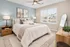 Elegant bedroom with a cozy king-size bed, stylish decor, and a large window providing ample natural light.