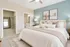 Inviting modern bedroom with a plush bed, elegant decor, ample natural light, walk-in closet, and en-suite bathroom.