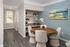Chic dining area with a round wooden table, plush beige chairs, and elegant built-in shelving against a soft blue accent wall.