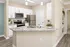 Modern kitchen with sleek granite countertops, stainless steel appliances, and elegant white cabinetry, perfect for stylish living.