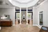 Elegant apartment interior featuring a spacious, light-filled living area with chic furnishings and grand columns.