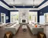 Elegant open-concept living space featuring modern sofas, chic decor, and a stylish stone fireplace, ideal for relaxation and entertaining.