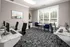 Contemporary office space with sleek black chairs, modern workstations, and a large window offering natural light.