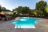 Inviting outdoor pool area with lounge chairs, surrounded by lush greenery and modern apartment buildings.